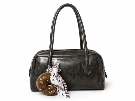 BOLSO BAGUETTE EN CUERO SINTÉTICO, CHARM DE PELUCHE DONA Y BOLSILLO INTERNO.