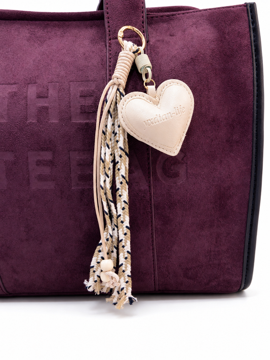 CHARM DE CORAZÓN EN CUERO SIINTÉTICO, CON CORDÓN TRENZADO Y CHAQUIRAS.